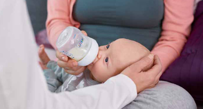 a baby being fed by a baby bottle