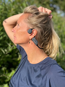Žena nosi Philips Bluetooth slu&scaron;alice sa tehnologijom ko&scaron;tane provodljivosti