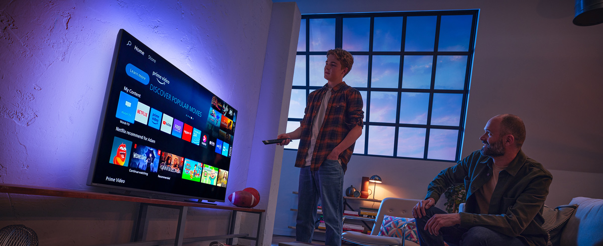 Muškarac bira aplikaciju na Philips Smart televizoru
